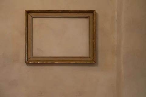 Empty frame with no painting in it hanging on a pale orange wall with Venetian Stock Photos