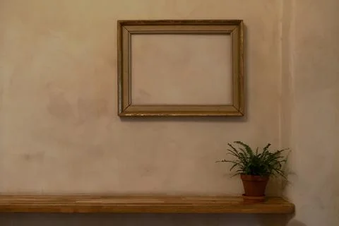 Empty frame with no painting in it hanging on a pale orange wall with Venetian Stock Photos