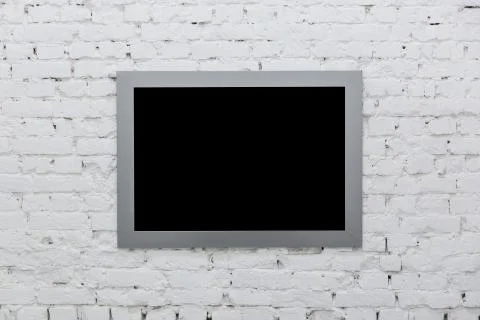 Empty frame from a painting on a white brick wall. Black place mock up Stock Photos