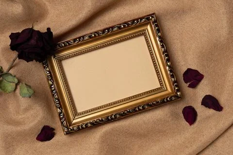 Empty frame with rose on a fabric background from above. Vintage style. Top.. Stock Photos