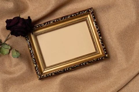 Empty frame with rose on a fabric background from above. Vintage style. Top v Stock Photos