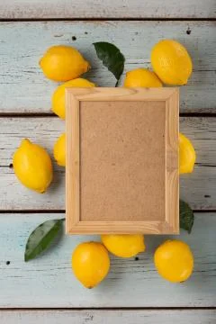 Empty frame for text with lemons and green leaves, top view Foto stock