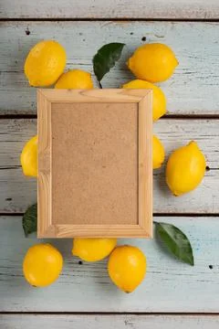 Empty frame for text with lemons and green leaves, top view Foto stock