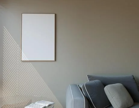Empty framed canvas on neutral wall, beside a gray couch. Sunlight casts di.. Stock Illustration