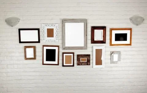 Empty frames and lamps on white bagged wall Stock Photos