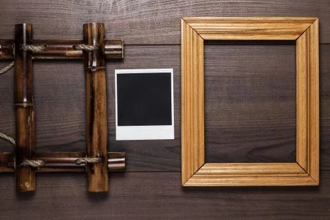 Empty frames and old photo on wooden table background Stock Photos