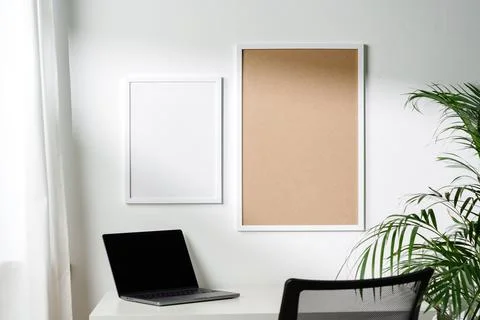 Empty frames on the wall above the working table in the office Stock Photos