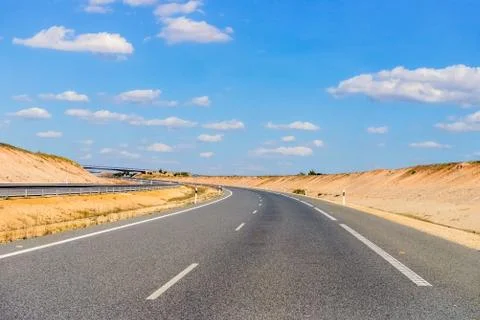 Empty freeway against a blue sky with clouds Stock Photos