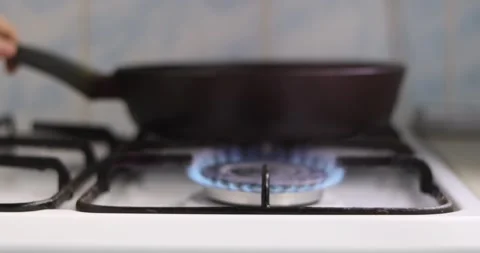 An empty frying pan sits on a hot gas stove, heating up. Close-up 4k. 库存影片 300363866