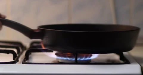 An empty frying pan sits on a hot gas stove, heating up. Close-up 4k. Stock Footage 300363886