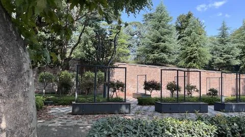 Empty garden with brick wall and metal planters Stock-Fotos