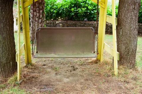 Empty Garden Swing Bench with Yellow Frame in a Quiet Outdoor Park Stock Photos