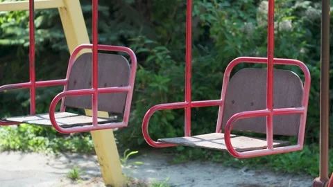 Empty garden swings beneath leafy trees Stock Footage 346638289