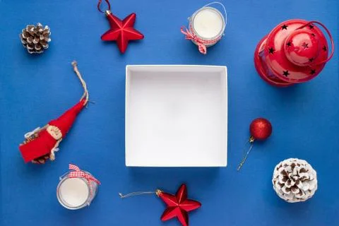 Empty gift box surrounded with Christmas decorations. Copy space on white gif Stock Photos