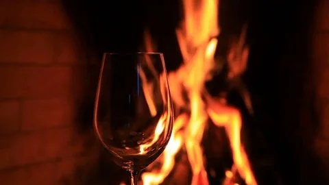 Empty glass against the fire in the fireplace Stock Footage 81697499