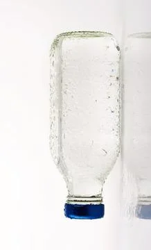 Empty glass bottle with blue cap Stock Photos