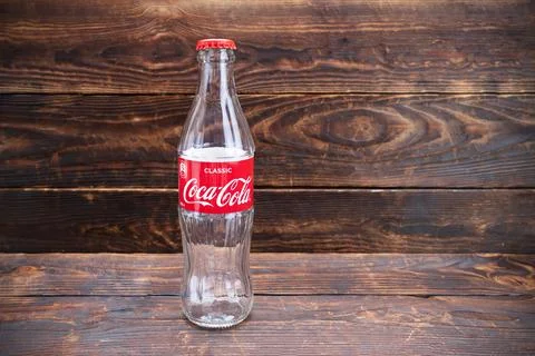 Empty glass bottle of coca cola with red cap and label, 0.33 l. Stock Photos