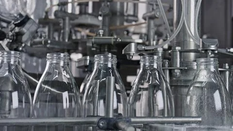 Empty glass bottles moving along conveyor belt in dairy plant Stock Illustration