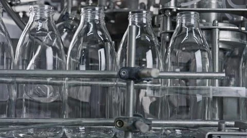 Empty glass bottles moving on conveyor belt in dairy plant Stock Illustration