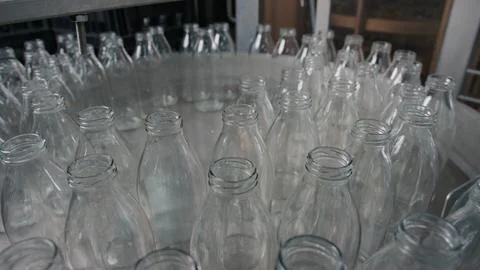 Empty glass bottles moving on conveyor belt in dairy factory Stock Illustration