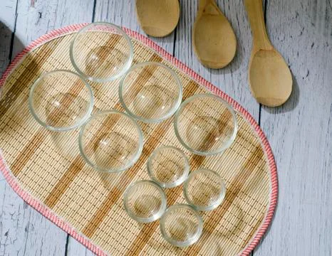 Empty glass bowls and wooden spoons on a white wooden plank background. mock up. Stock Photos