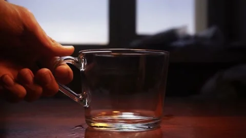Empty glass cup is being put on a wooden table with a widow on background 스톡 동영상 168248390