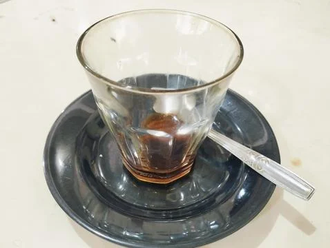 An empty glass cup of coffee on the white table Stock Photos