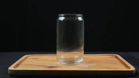 Empty glass cups and straws on wooden tray isolated on dark background Stock Photos