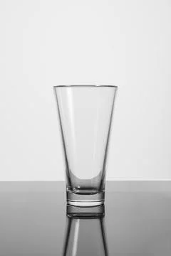 Empty glass goblet with reflection on a white background. Stock Photos
