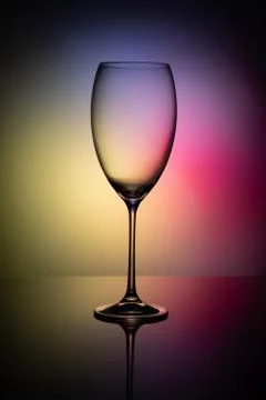 Empty glass goblet without wine on a thin leg stands on a mirror surface. Foto stock