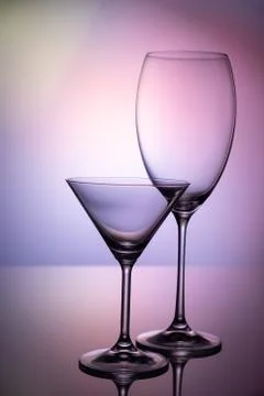 Empty glass goblets set. On a colored purple background abstract Stock Photos