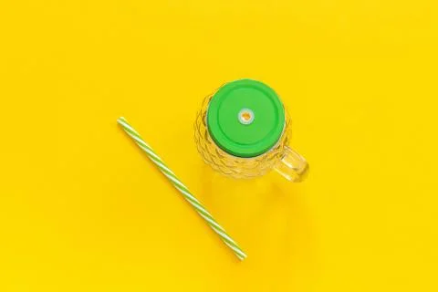 Empty glass jar in form of pineapple with green lid and straw for fruit or ve Foto stock