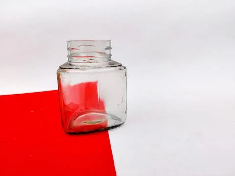 Empty glass jar on red sheet. Isolated on white background. Stock Photos