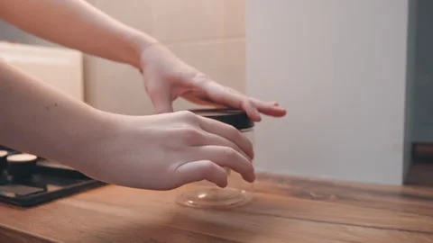 Empty glass jar on wood counter, caucasian hands gently set lid, stove Stock Footage 337465596
