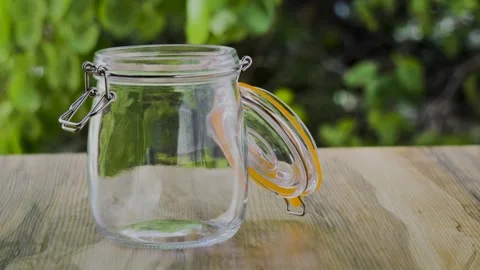 Empty glass jar on wooden table with swaying leaves background 4k Vidéo 341268958