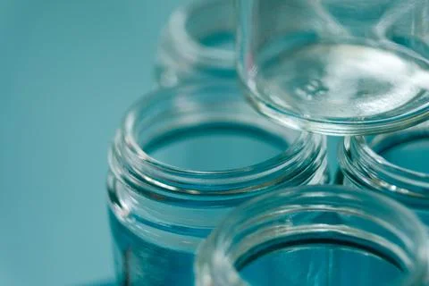 Empty glass jars with threaded rims and blue background Stock Photos