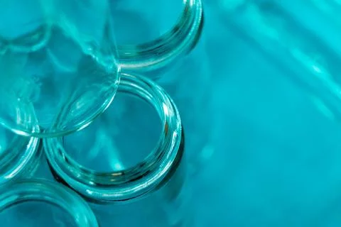 Empty glass jars with threaded rims and cool blue background Stock Photos