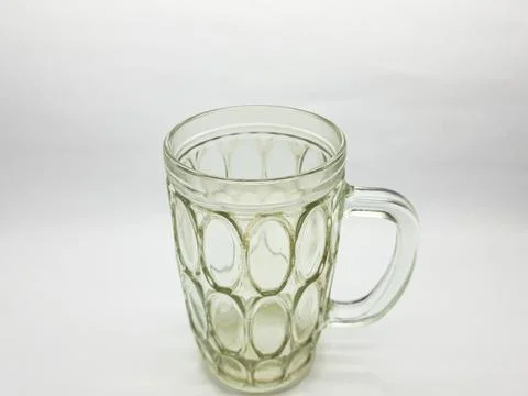 Empty glass mug with a pattern sitting on a white surface studio shot Stock Photos