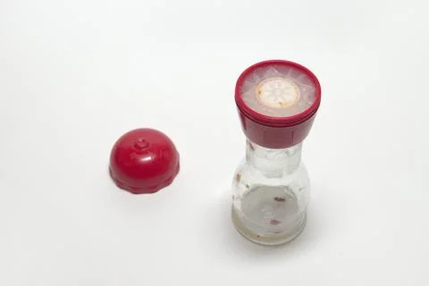 Empty glass pepper mill with two degrees of grind, with the red cover, laying Stock Photos