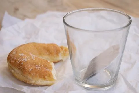 Empty glass with tea bag and pastry Stock Photos