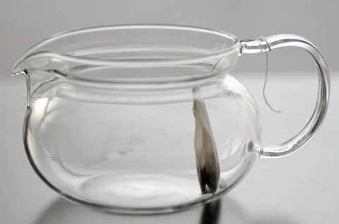 Empty glass tea pot with tea bag Stock Photos