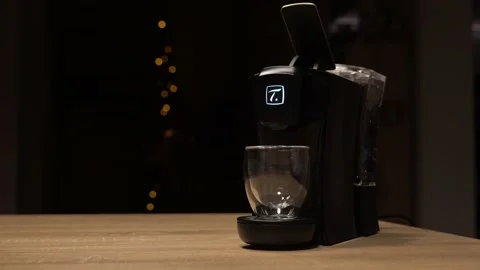 Empty glass under tea machine with lights in background Stock Footage 144439403