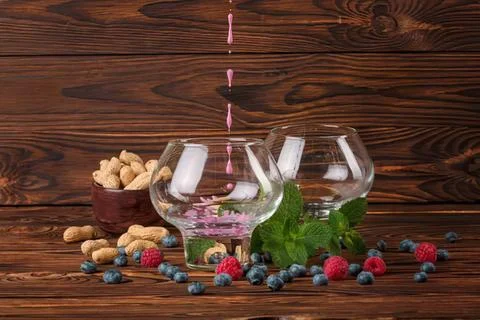 Empty glasses with berries and nuts on wooden table Stock Photos