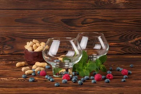 Empty glasses with candy and chocolate on wooden table Stock Photos