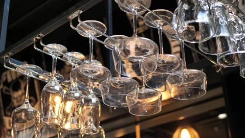Empty glasses hang upside down over the bar counter. Stock Footage 272337132
