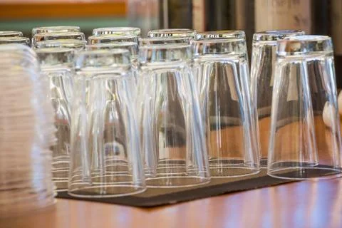 Empty glasses for juice at the bar. Stack of cleaned glasses on bar counter Stock Photos