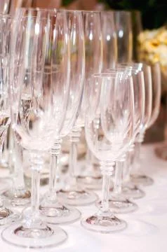 Empty glasses stand on a table on a white tablecloth. Waiting for the holiday Stock Photos