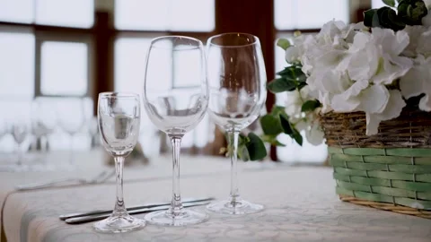 Empty glasses for wine and pink flowers bouquet on white tablecloth arranged for Stock Footage 139390670