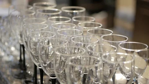 Empty glasses for wine standing in a row on serving table during the celebration Stock Footage 89670144