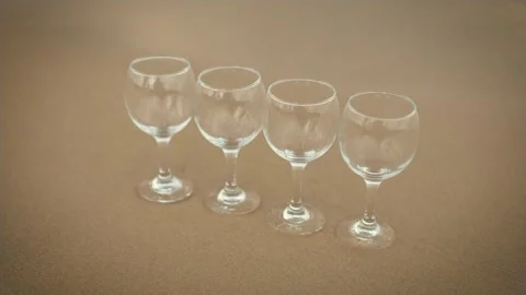 Empty glasses for wine standing in row near ocean beach with water waves Video stock 254087842